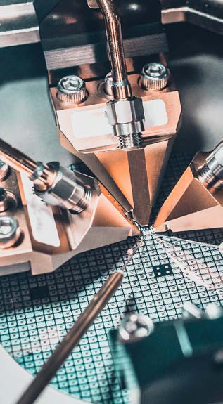 Close-up of semiconductor wafer probe testing equipment on a manufacturing line