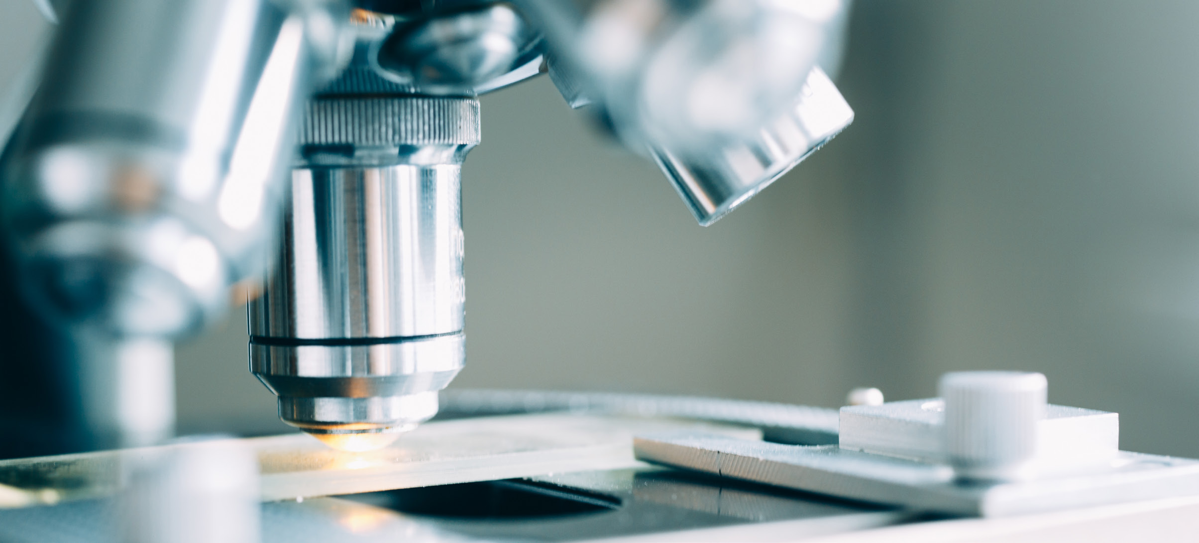 Laboratory microscope examining a sample, representing the engineered chemistry behind PFAS materials