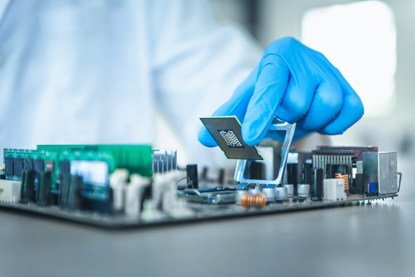 Gloved hand placing a chip onto a circuit board